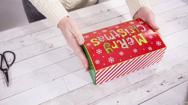 Passo dopo passo. Confezionamento di caramelle e biscotti fatti in casa in una confezione regalo di Natale.