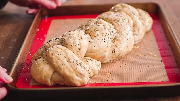 Passo dopo passo. Cospargere di semi di sesamo e papavero sul pane challah.