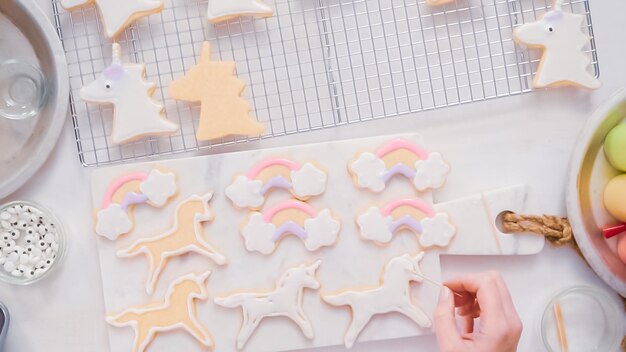 Passo dopo passo. Decorare biscotti di zucchero a forma di unocrn con glassa reale per la festa di compleanno della bambina.