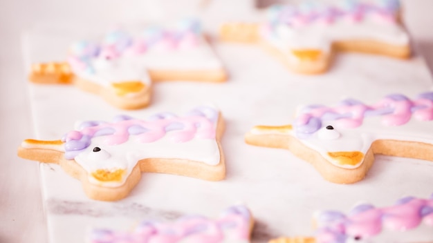 Passo dopo passo. Decorare biscotti di zucchero a forma di unocrn con glassa reale per la festa di compleanno della bambina.