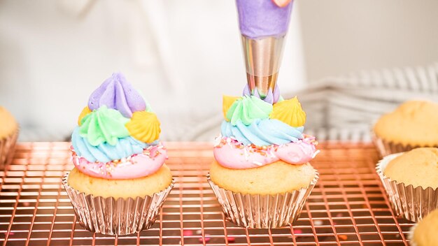 Passo dopo passo. Decorare cupcakes alla vaniglia a tema unicorno con glassa di crema al burro arcobaleno.