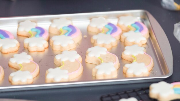 Passo dopo passo. Decorare i biscotti di zucchero di unicorno con glassa reale sulla teglia.