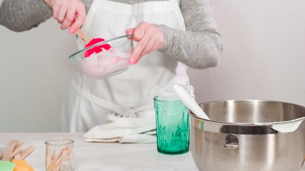 Passo dopo passo. Disposizione piatta. Mescolare la ghiaccia reale nello sbattitore elettrico da cucina per i biscotti di Pasqua.