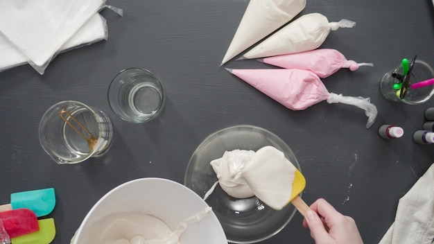 Passo dopo passo. Disposizione piatta. Unire il colorante alimentare alla ghiaccia reale per decorare i biscotti di zucchero.