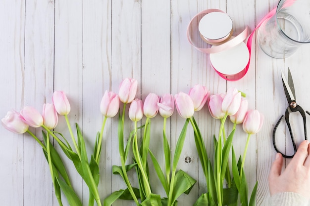 Passo dopo passo. Fiorista che avvolge i tulipani rosa nel bouquet.