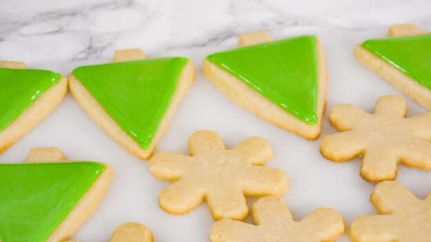 Passo dopo passo. Glassa di biscotti di zucchero a forma di albero di Natale con glassa reale verde.