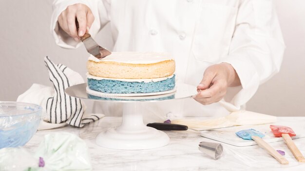 Passo dopo passo. Impilare gli strati di torta per creare la torta rotonda alla vaniglia a tre strati.