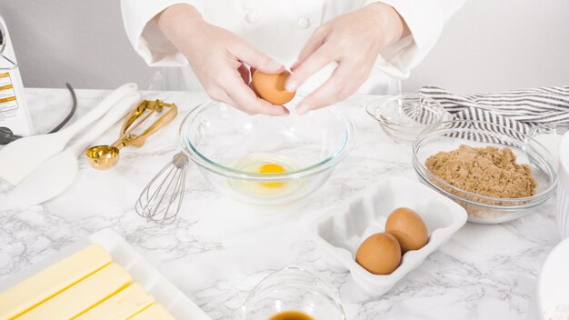 Passo dopo passo. Mescolare gli ingredienti in una ciotola di vetro per fare i biscotti con gocce di cioccolato.