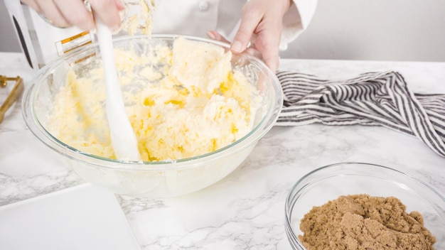 Passo dopo passo. Mescolare gli ingredienti in una ciotola di vetro per fare i biscotti con gocce di cioccolato.