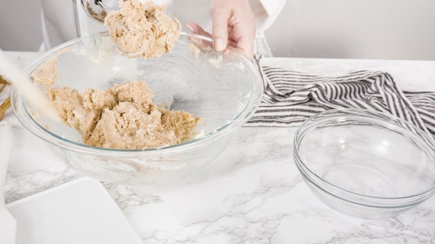 Passo dopo passo. Mescolare gli ingredienti in una ciotola di vetro per fare i biscotti con gocce di cioccolato.