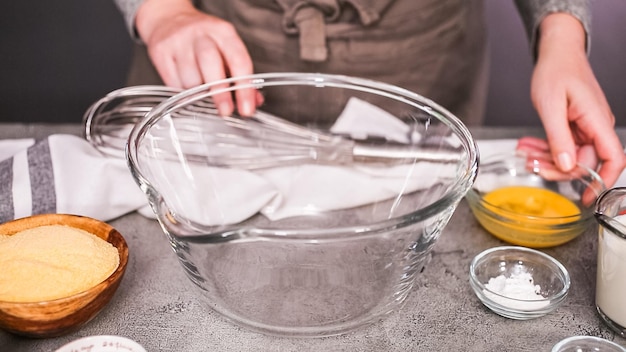 Passo dopo passo. Mescolare gli ingredienti insieme in una ciotola di vetro per muffin speziati di pane di mais jalapeno.