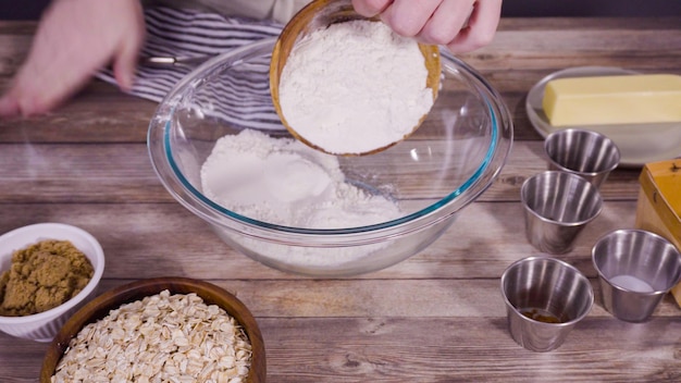 Passo dopo passo. Mescolare gli ingredienti per cuocere i biscotti di farina d'avena in una terrina di vetro.