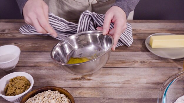 Passo dopo passo. Mescolare gli ingredienti per cuocere i biscotti di farina d'avena in una terrina di vetro.