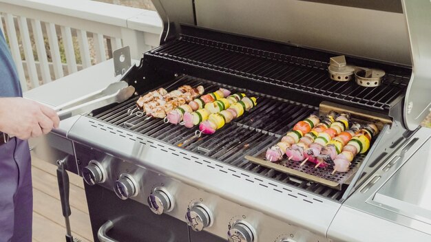 Passo dopo passo. Passo dopo passo. Grigliare spiedini di verdure e spiedini di pollo sul grill a gas all'aperto.