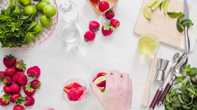 Passo dopo passo. Preparazione del mojito alla fragola da fragole fresche biologiche.