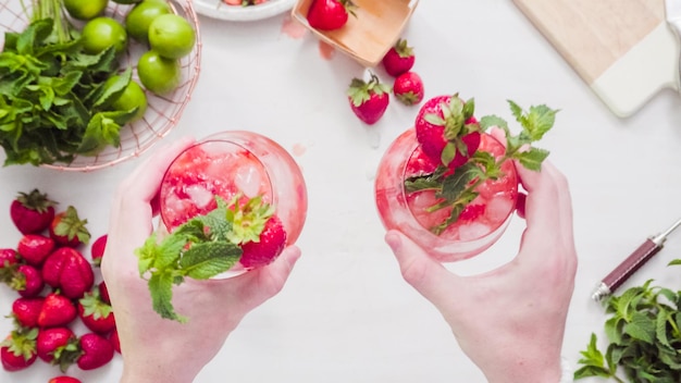 Passo dopo passo. Preparazione del mojito alla fragola da fragole fresche biologiche.