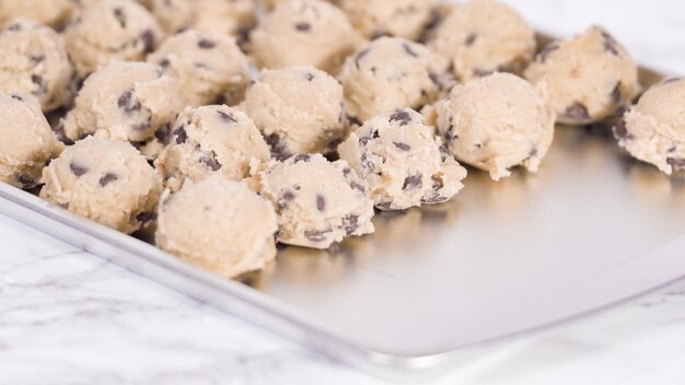 Passo dopo passo. Raccogliere i biscotti con gocce di cioccolato fatti in casa con un cucchiaio di pasta di metallo sulla teglia.