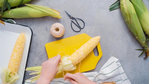 Passo dopo passo. Sgusciare il mais biologico per fare la pannocchia di mais messicana Elote.