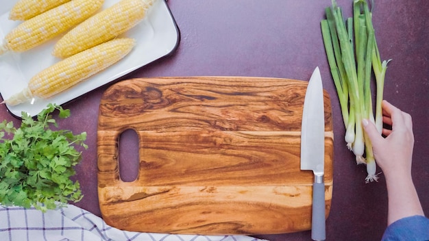 Passo dopo passo. Tagliere di legno vuoto con un grande coltello da cucina.