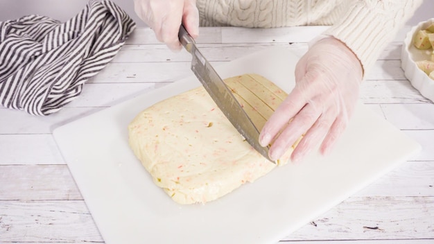 Passo dopo passo. Taglio di zucchero filato fatto in casa su un tagliere bianco.