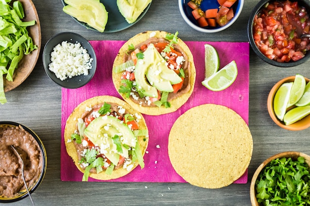 Passo dopo passo. Tostadas messicani vegetariani freschi sul tagliere viola.