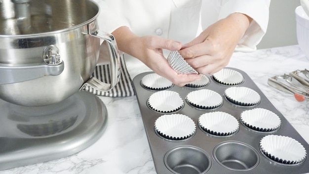 Passo dopo passo. Versare la pastella con il misurino nello stampo per cupcake foderato con pirottini di carta.