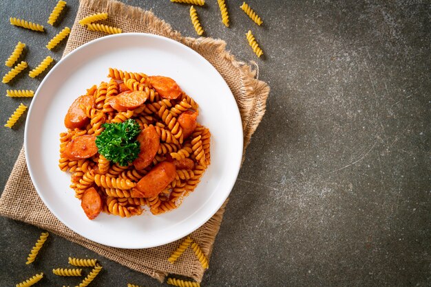 pasta a spirale o spirali con salsa di pomodoro e salsiccia - stile alimentare italiano