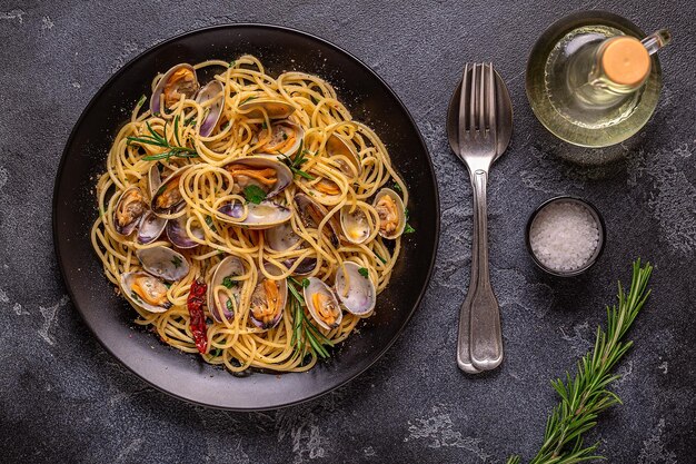 Pasta ai frutti di mare con vongole Spaghetti alle Vongole su sfondo scuro Vista dall'alto