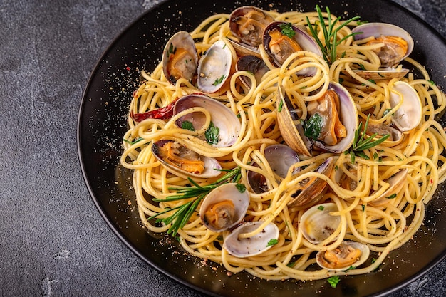 Pasta ai frutti di mare con vongole Spaghetti alle Vongole su sfondo scuro