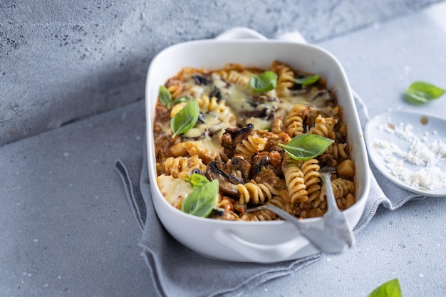 Pasta al forno con carne di verdure e funghi prataioli in una ciotola Primo piano