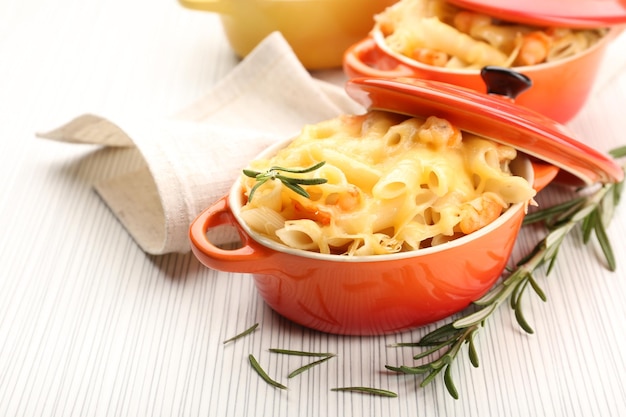 Pasta al forno con gamberi e formaggio in pentola di ceramica