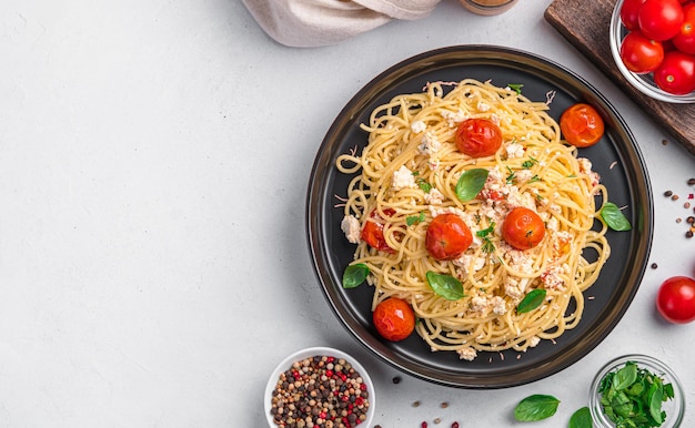 Pasta al forno con pomodori feta e aglio Pasta feta alla moda con erbe e basilico su sfondo grigio Spazio per la copia della vista dall'alto