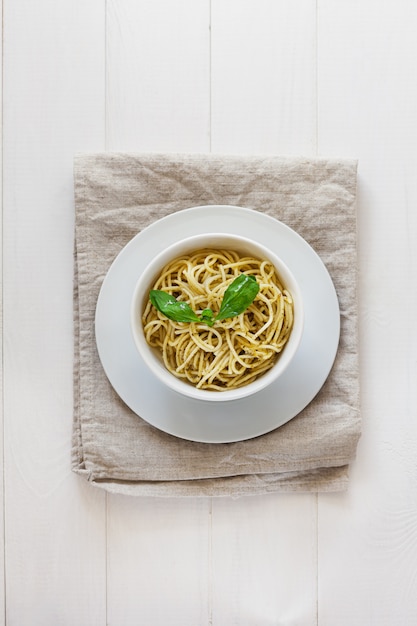 Pasta al pesto in un piatto bianco su sfondo chiaro