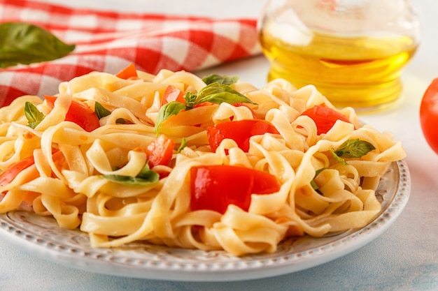 Pasta al pomodoro servita con basilico, fuoco selettivo.