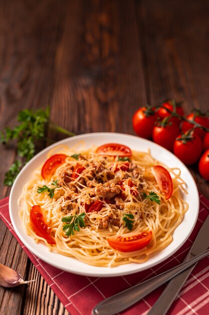 Pasta alla bolognese con salsa di pomodoro e carne macinata, parmigiano grattugiato e prezzemolo fresco - pasta italiana sana fatta in casa