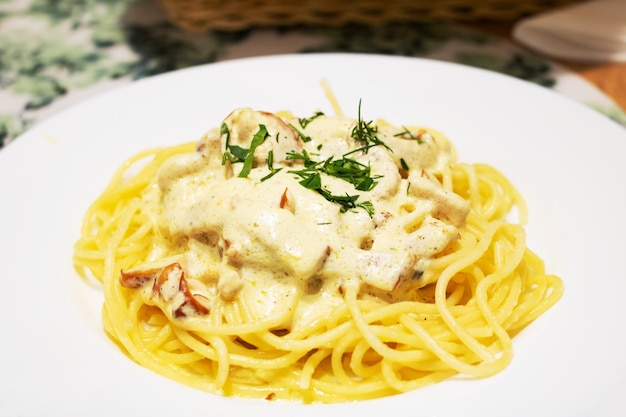 Pasta alla carbonara con formaggio su un piatto bianco