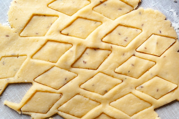 Pasta arrotolata Formare la pasta per cuocere i biscotti Soft focus selettivo Cibo fatto in casa