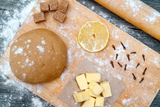 Pasta biscotto. sul tavolo della cucina. Ingredienti - burro, limone, farina, zucchero, chiodi di garofano.