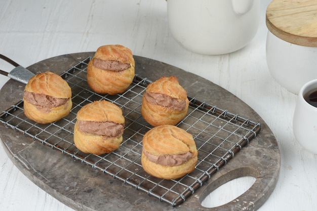 pasta choux o bignè ripieni di crema pasticcera al cioccolatofondo bianco