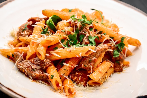 Pasta con carne di vitello, salsa di pomodoro e formaggio su un tavolo in un ristorante