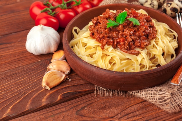 Pasta con carne, salsa di pomodoro e verdure sul tavolo