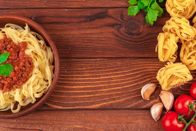 Pasta con carne, salsa di pomodoro e verdure sul tavolo