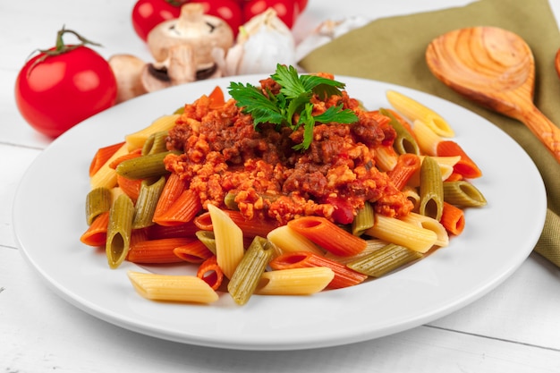 Pasta con carne, salsa di pomodoro e verdure sul tavolo