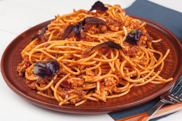 Pasta con carne, salsa di pomodoro e verdure sul tavolo