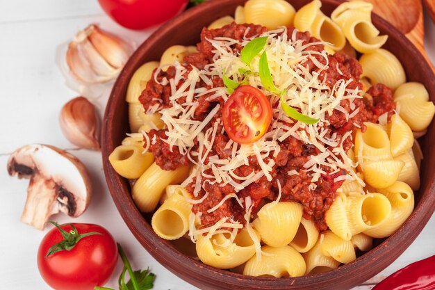 Pasta con carne, salsa di pomodoro e verdure sul tavolo