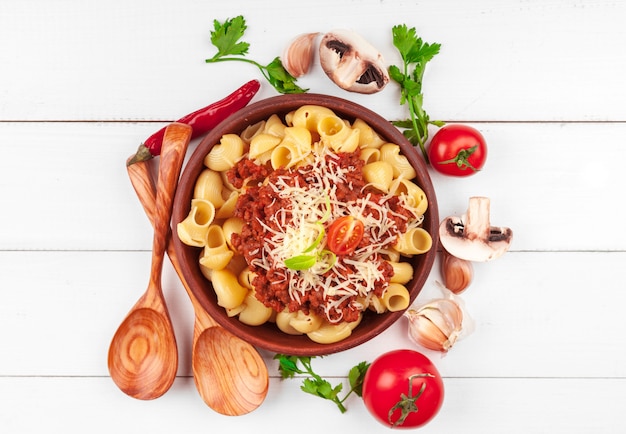 Pasta con carne, salsa di pomodoro e verdure sul tavolo