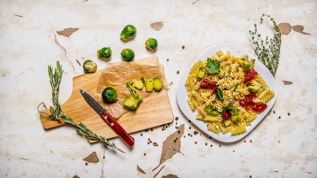 Pasta con cavoletti di Bruxelles, erbe aromatiche e spezie. Sulla tavola rustica. Vista dall'alto