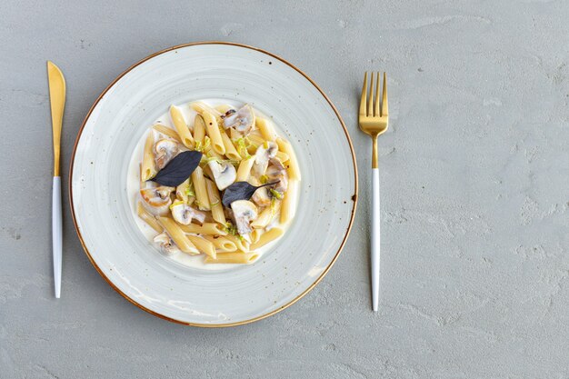 Pasta con funghi e salsa di panna servita sul piatto