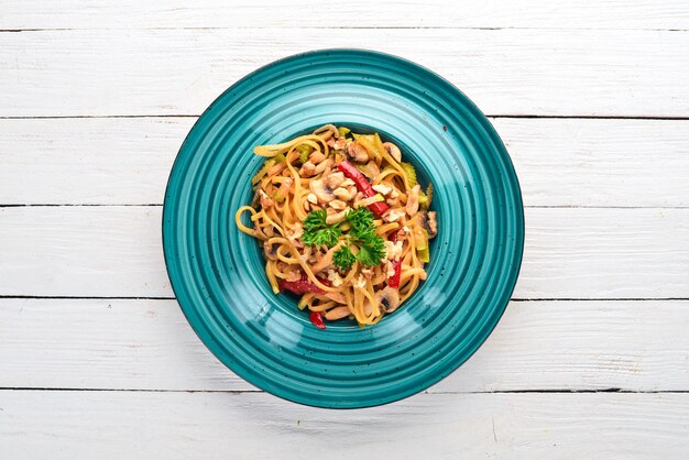 Pasta con funghi e verdure Cucina italiana su fondo in legno Vista dall'alto Copia spazio