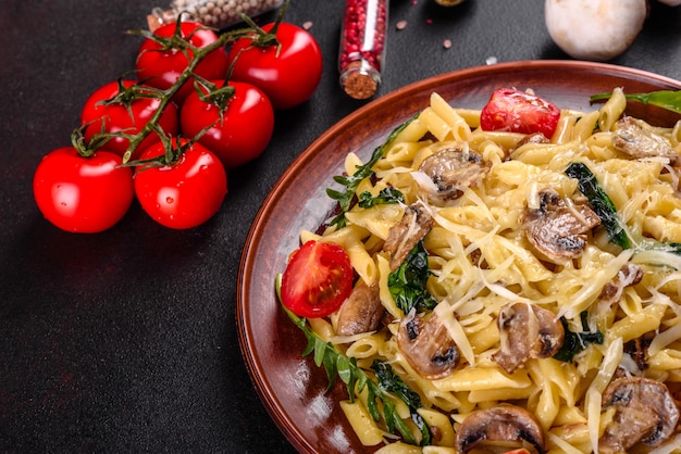 Pasta con funghi, formaggio, spinaci, rukkola e pomodorini. Piatto italiano, cultura mediterranea